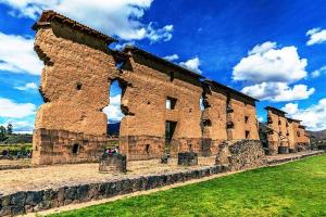 un gran edificio de ladrillo al lado de un campo en Casa Amaru Raqchi, en Anansaya