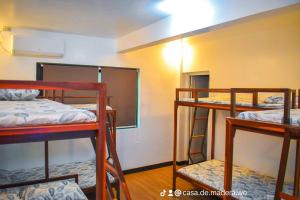 a room with three bunk beds and a mirror at Casa de Madera The Wooden House Staycation Transient and Private Resort in Cabuyao +39 photos