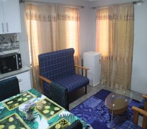 a living room with a blue chair and a table at Mount Olivet House in Suva
