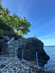 un camino de piedra que conduce al océano en un acantilado en Tongatok Cliff Resort en Mambajao