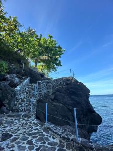 a stone path leading to the ocean on a cliff at Tongatok Cliff Resort in Mambajao