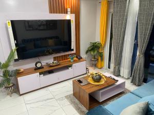 een woonkamer met een grote flatscreen-tv bij Residence Therese La Grâce in Douala