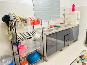 a kitchen with a sink and a counter with dishes at Resthouse Asyura in Malacca