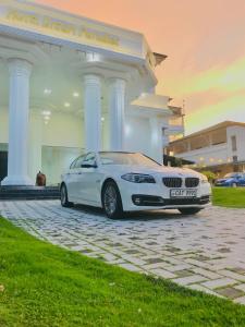 a white car parked in front of a building at Hotel Dream Paradise in Ja-Ela
