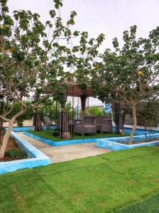 a garden with a gazebo and trees at استراحه ابو فهد in Al Qurayn
