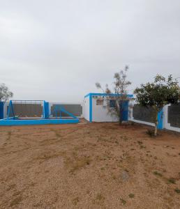 a building with blue and white in a field at استراحه ابو فهد in Al Qurayn