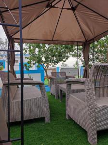 a group of tables and chairs under an umbrella at استراحه ابو فهد in Al Qurayn