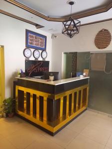 EXPRESS HOTEL في لاهور: كونتر في مطعم مع ساعات على الحائط