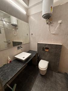 y baño con lavabo, aseo y espejo. en Atulya Green By Meyatri, en Jaipur