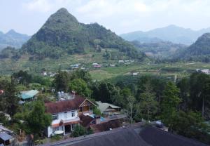 - une vue sur un village avec des montagnes en arrière-plan dans l'établissement Huy Trung Homestay, à Bắc Hà