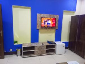 EXPRESS HOTEL في لاهور: غرفة مع تلفزيون على جدار أزرق