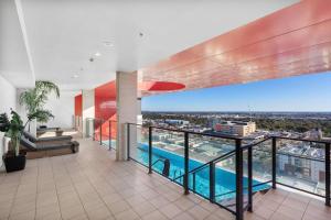 einen Blick vom Balkon eines Gebäudes mit Pool in der Unterkunft Luxe Cityscape Living in Adelaide