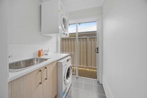 una cocina con fregadero y lavadora en Fairway to Heaven, en Sussex Inlet 11 fotos más