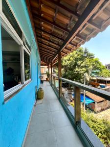Casa azul con balcón con piscina en House TT do Vidigal, en Río de Janeiro