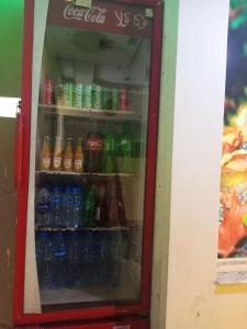 EXPRESS HOTEL في لاهور: مبرد مليء بقوارير المشروبات الغازية
