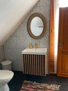 a bathroom with a sink and a mirror and a toilet at Rakši in Cēsis