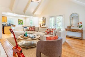 uma sala de estar com um sofá e uma guitarra em Orchard by AvantStay Whimsical Home w Lush Backyard em Isle of Palms