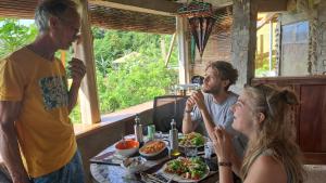 un grupo de personas sentadas en una mesa con comida en Camiguin Romantic Luxury Stonehouse on Eco-Farm at 700masl en Mambajao