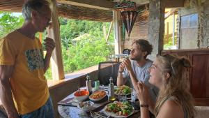 a group of people sitting at a table with food at Eco Farm Romantic Stone House with STARLINK internet 700 meters above sea level in Mambajao +59 photos