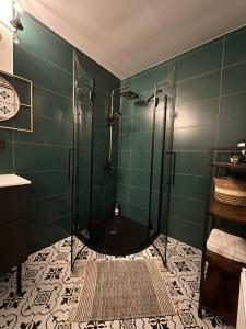 baño verde con ducha con puerta de cristal en Rakši en Cēsis