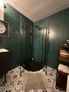 a green bathroom with a shower with a glass door at Rakši in Cēsis