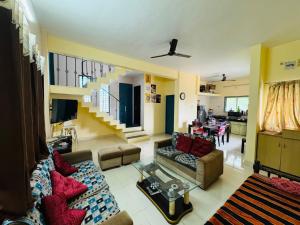 浦那的住宿－Swaradhya Hillside Villa 3BHK -AC - WiFi - SmartTV - Parking - Kitchenette - Near Lonavala，带沙发的客厅和用餐室