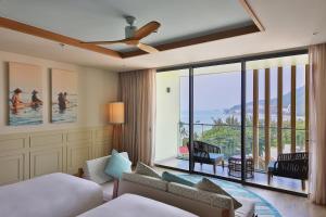 a hotel room with a bed and a large window at Fusion Suites Vung Tau in Vung Tau +37 photos