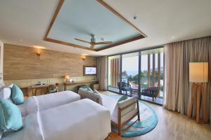 a hotel room with a bed and a living room at Fusion Suites Vung Tau in Vung Tau