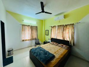 浦那的住宿－Swaradhya Hillside Villa 3BHK -AC - WiFi - SmartTV - Parking - Kitchenette - Near Lonavala，一间卧室配有一张床和吊扇
