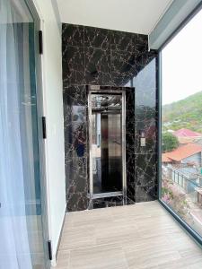 a bathroom with a mirror and a black wall at Homeatay & Apartment CHÂU SƠN in Vung Tau