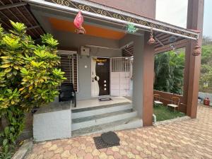 une maison avec des escaliers menant à la porte d'entrée. dans l'établissement Swaradhya Hillside Villa 3BHK -AC - WiFi - SmartTV - Parking - Kitchenette - Near Lonavala, à Pune