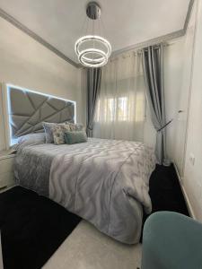 a bedroom with a large bed and a chandelier at Home S&F- Algorfa in Algorfa