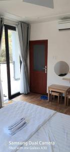 a room with a bed and a sliding glass door at Homeatay & Apartment CHÂU SƠN in Vung Tau