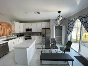 a kitchen with a glass table and chairs in it at Family vacation home by Disney in Davenport