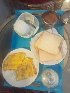 EXPRESS HOTEL في لاهور: طاولة عليها أطباق من طعام الإفطار