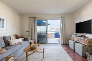 uma sala de estar com um sofá e uma televisão de ecrã plano em Bay View II by AvantStay Ocean View Mission Beach Home on the Sand em San Diego