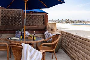 a table and chairs with an umbrella on the beach at Bay View II by AvantStay Ocean View Mission Beach Home on the Sand in San Diego