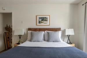um quarto com uma cama com um cobertor azul e 2 candeeiros em Bay View II by AvantStay Ocean View Mission Beach Home on the Sand em San Diego