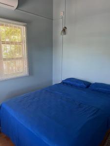 - un lit bleu dans une chambre avec fenêtre dans l'établissement Glory's River View, à DʼArbeau