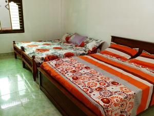 2 nebeneinander sitzende Betten in einem Schlafzimmer in der Unterkunft Nallur Mylooran Arangam in Jaffna