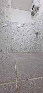 a room with a white stone wall with a shower at FATINN'S surf Apartements in Airsatang +56 photos