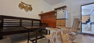 a kitchen with a wooden table and a refrigerator at FATINN'S surf Apartements in Airsatang