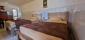 a bedroom with two beds in a room at FATINN'S surf Apartements in Airsatang