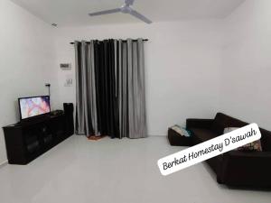 a living room with a couch and a tv at Homestay Berkat D'sawah Tasek Berangan Pasir Mas in Pasir Mas