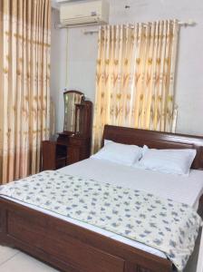 a bedroom with a bed with a wooden headboard at BB homestay in Thôn Tiên Nộn