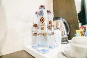 duas garrafas de água sentadas em cima de um balcão em The one boutique hotel em Satun