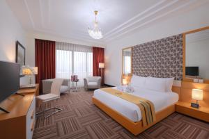 Habitación de hotel con cama grande y TV en Merlynn Park Hotel, en Yakarta