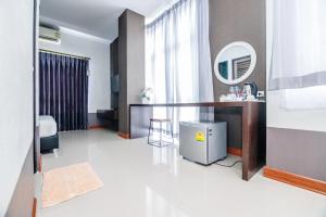 een hotelkamer met een bureau en een spiegel bij The one boutique hotel in Satun
