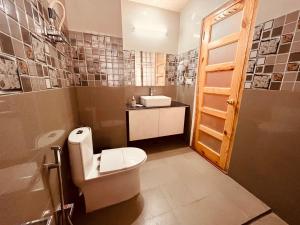 Vista Resort, Manali - centrally Heated & Air cooled luxury rooms في مانالي: حمام مع مرحاض ومغسلة