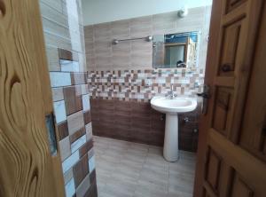 La salle de bains est pourvue d'un lavabo et d'un miroir. dans l'établissement Marina Residency, à Muzaffarabad